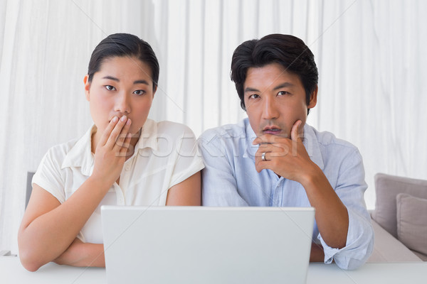 Preocupado casal usando laptop juntos casa sala de estar Foto stock © wavebreak_media