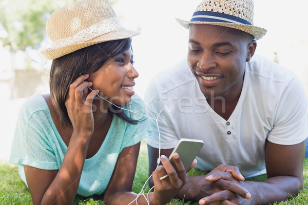 Happy couple lying in garden together listening to music Stock photo © wavebreak_media