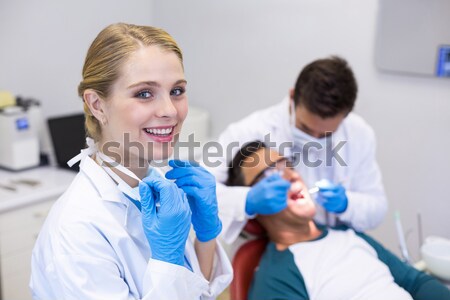 Pediatric dentist showing little boy how to brush his teeth Stock photo © wavebreak_media