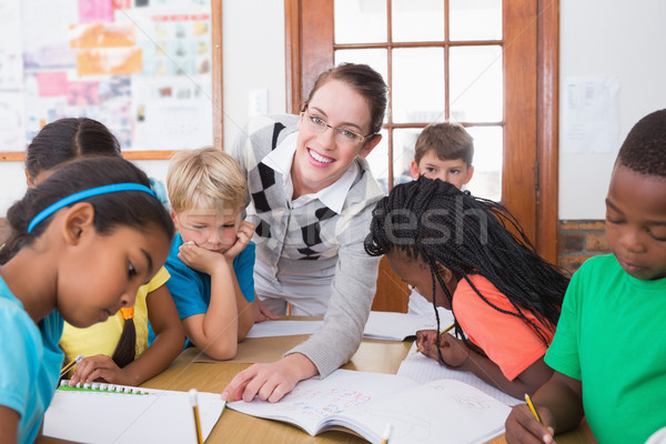 Teacher and pupils working at desk together Stock photo © wavebreak_media