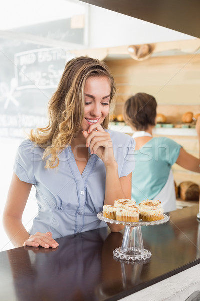 Pretty blonde being tempted by cupcakes Stock photo © wavebreak_media