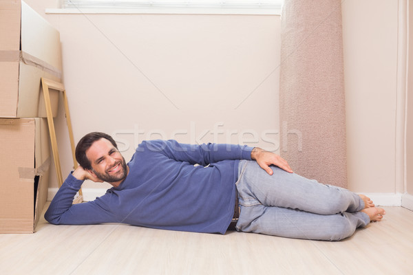 Stock photo: Happy man lying on floor with moving boxes