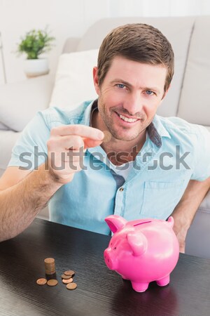улыбаясь человека монетами Piggy Bank диван счастливым Сток-фото © wavebreak_media