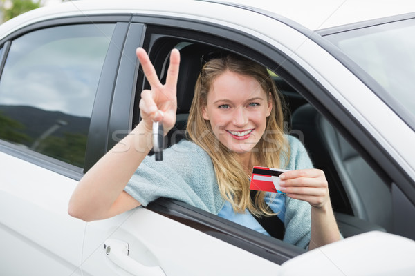 Young woman smiling and holding card Stock photo © wavebreak_media