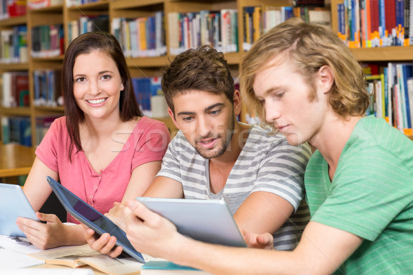 Stock photo: College students using digital tablets in library