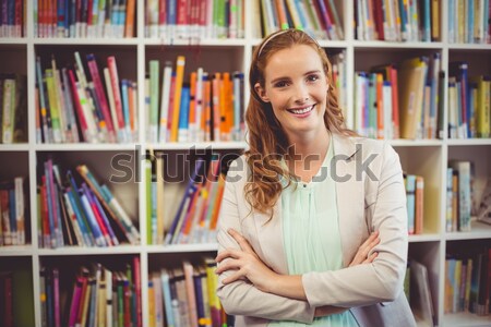 Glimlachend leerboek boekenkast universiteit Stockfoto © wavebreak_media