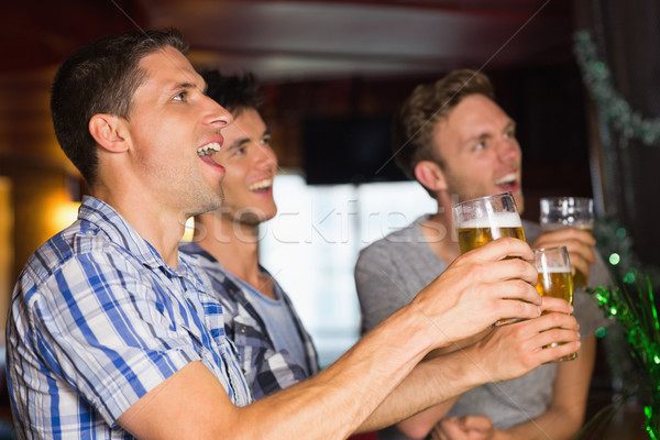 Happy friends toasting with pints of beer on patricks day Stock photo © wavebreak_media