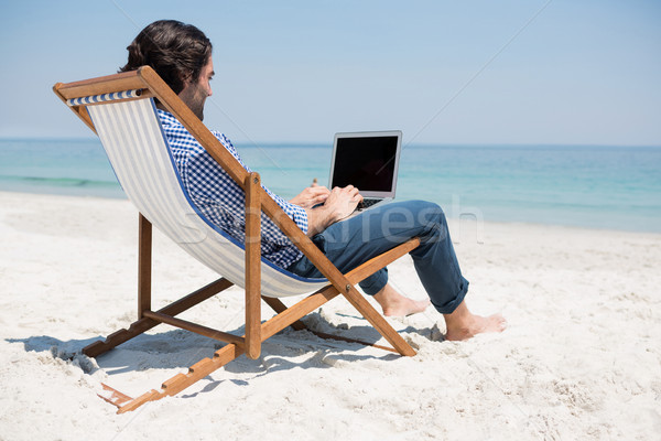 Stok fotoğraf: Yandan · görünüş · adam · dizüstü · bilgisayar · kullanıyorsanız · plaj · oturma · güverte