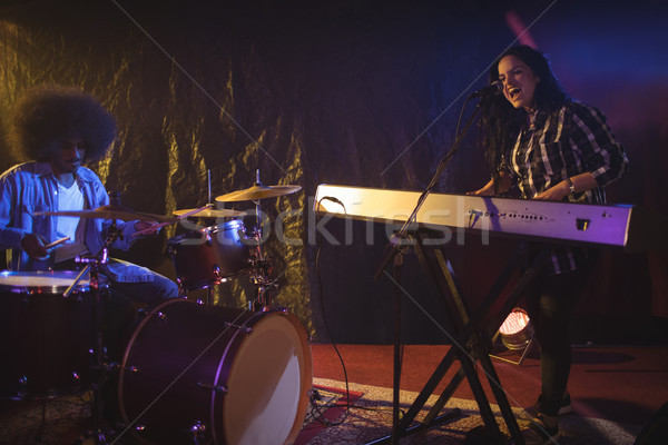 Singer and drummer performing in illuminated nightclub Stock photo © wavebreak_media