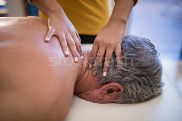 High angle view of female therapist giving neck massage to male patient Stock photo © wavebreak_media