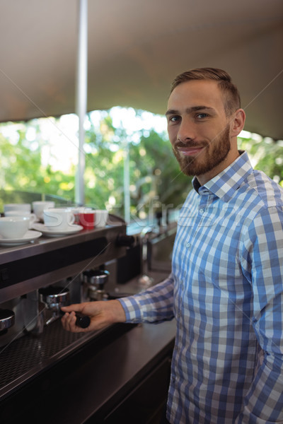 Waiter using tamper to press ground coffee into a portafilter Stock photo © wavebreak_media