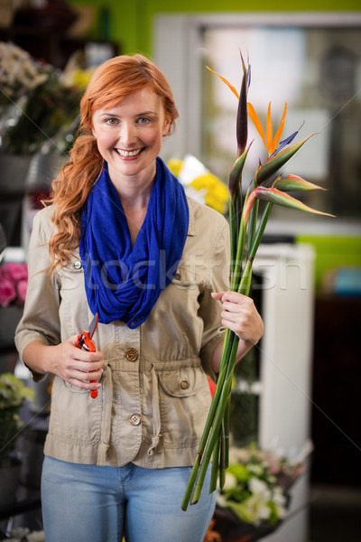Smiling female florist trimming flower stem Stock photo © wavebreak_media