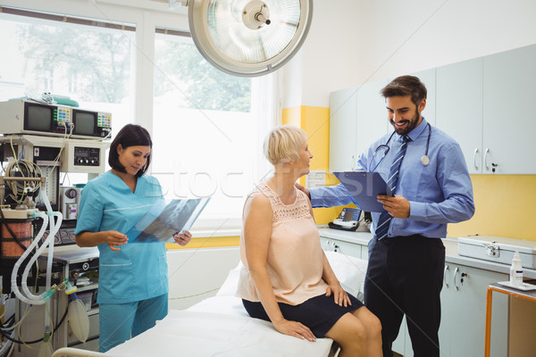 Male doctor interacting with a patient while nurse looking at x- Stock photo © wavebreak_media