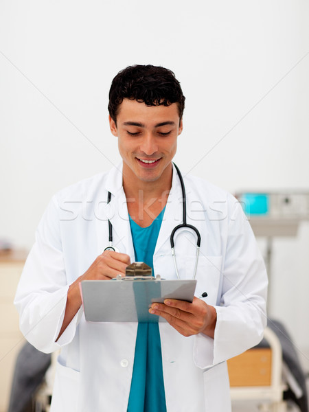 Stock photo: Young male Doctor holding a clip board