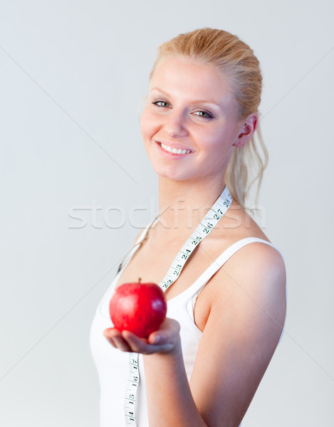 Beautiful woman holding an apple with focus on woman  Stock photo © wavebreak_media