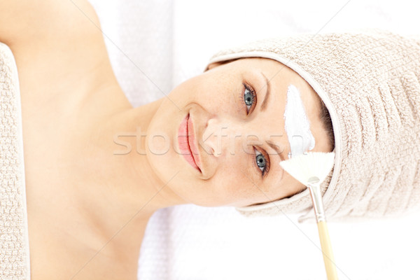 Pretty young woman receiving white cream on her face in a spa center Stock photo © wavebreak_media