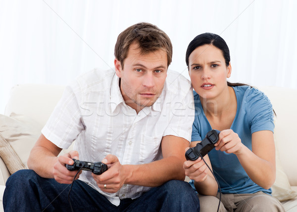 Concentré couple jouer jeux vidéo ensemble canapé [[stock_photo]] © wavebreak_media