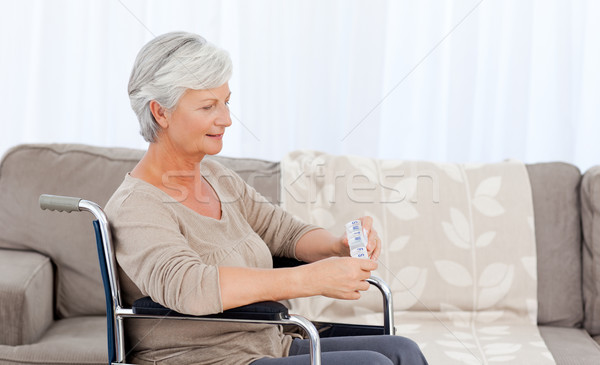 Stock photo: Senior in wheelchair with pills