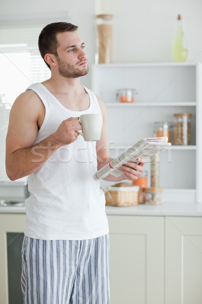 Portrait of a sports man drinking tea while reading the news in his kitchen Stock photo © wavebreak_media