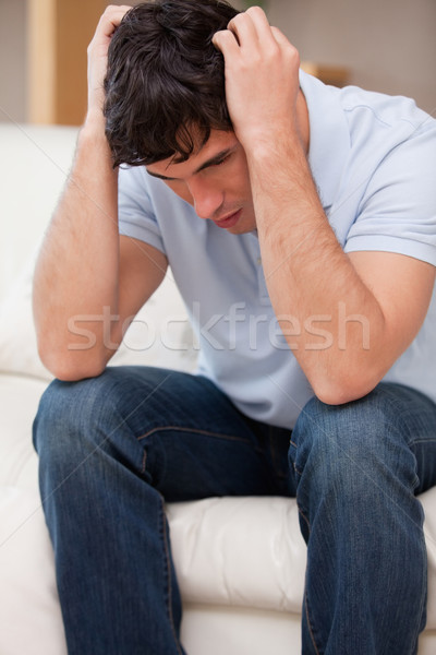 Frustrated young man sitting on the couch Stock photo © wavebreak_media