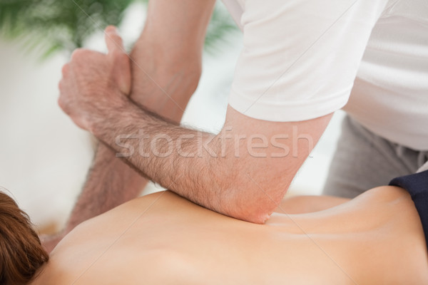 Doctor massaging his back of his patient while using his elbow in a room Stock photo © wavebreak_media