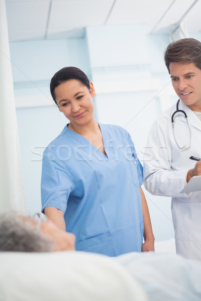 Doctor and nurse looking at a patient in hospital ward Stock photo © wavebreak_media