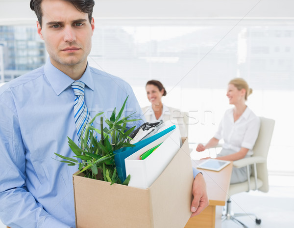 Businessman carrying his belongings with colleagues in backgroun Stock photo © wavebreak_media