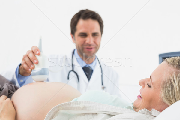 Smiling doctor doing a sonogram scan on pregnant woman Stock photo © wavebreak_media