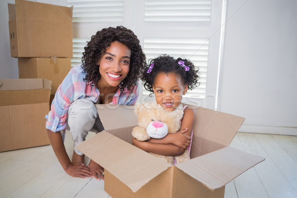 Cute daughter sitting in moving box with mother Stock photo © wavebreak_media