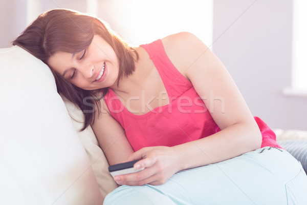 [[stock_photo]]: Joli · brunette · détente · canapé · smartphone · maison