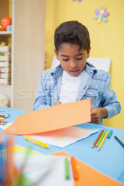 Cute little boy cutting paper shapes in classroom Stock photo © wavebreak_media