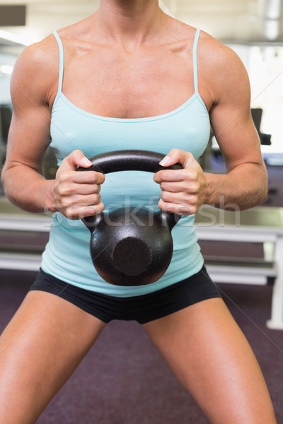 Mid section of a woman lifting kettle bell in gym Stock photo © wavebreak_media