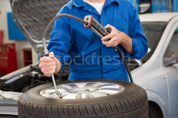 Close up of mechanic inflating the tire Stock photo © wavebreak_media