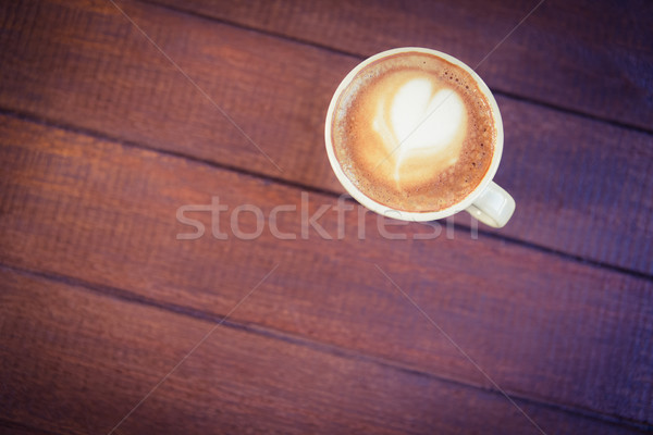 Cup of cappuccino with coffee art on wooden table Stock photo © wavebreak_media
