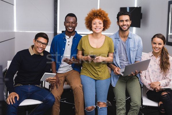 Portrait of happy business colleagues using various technologies Stock photo © wavebreak_media
