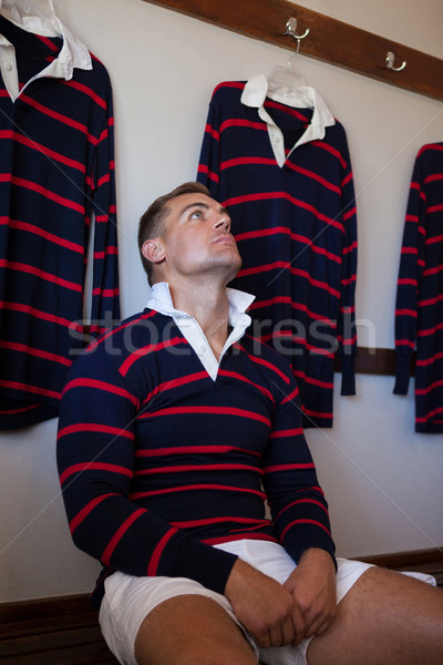 Tired rugby player looking up while sitting on bench Stock photo © wavebreak_media