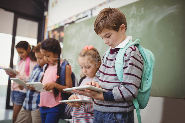 Attentive schoolkids using digital tablet in classroom Stock photo © wavebreak_media