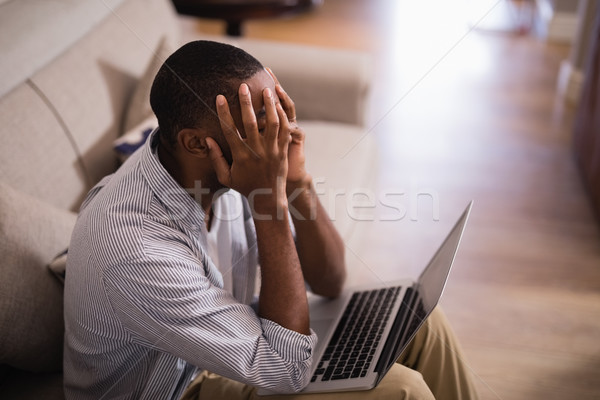 Frustrated man with laptop sitting at home Stock photo © wavebreak_media