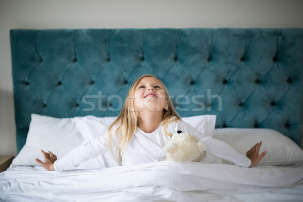 Girl stretching her arms while waking up in bedroom Stock photo © wavebreak_media