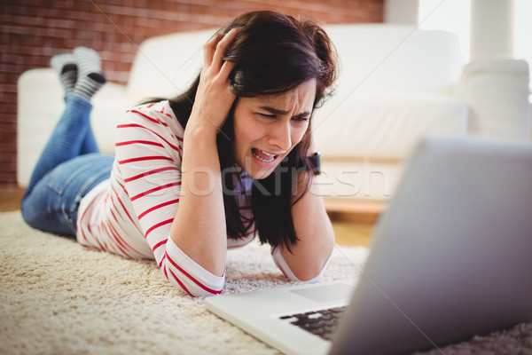 Hayal kırıklığına uğramış kadın dizüstü bilgisayar kullanıyorsanız genç kadın ev defter Stok fotoğraf © wavebreak_media