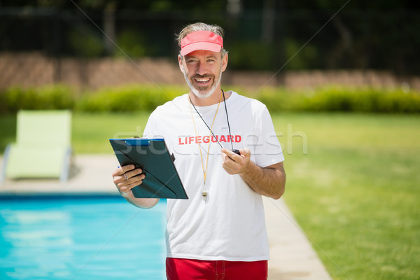 Portrait of swim coach holding stopwatch and clipboard near poolside Stock photo © wavebreak_media