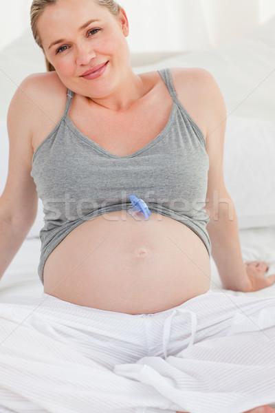 Pregnant woman with a baby dummy on her belly at home Stock photo © wavebreak_media