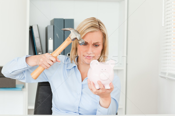 determined woman wanting to destroy her piggy bank in her office Stock photo © wavebreak_media