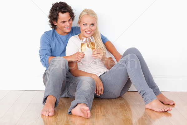 Portrait of a couple toasting while sitting on the floor Stock photo © wavebreak_media