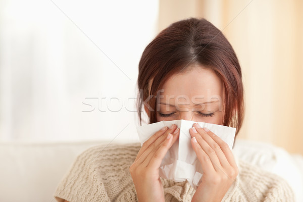 Sneezing cute woman in a living room Stock photo © wavebreak_media