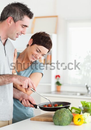 Cute Woman looking into a pan her husband is holding in a kitchen Stock photo © wavebreak_media
