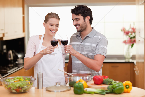 Stock photo: Couple drinking a glass of wine in their kitchen