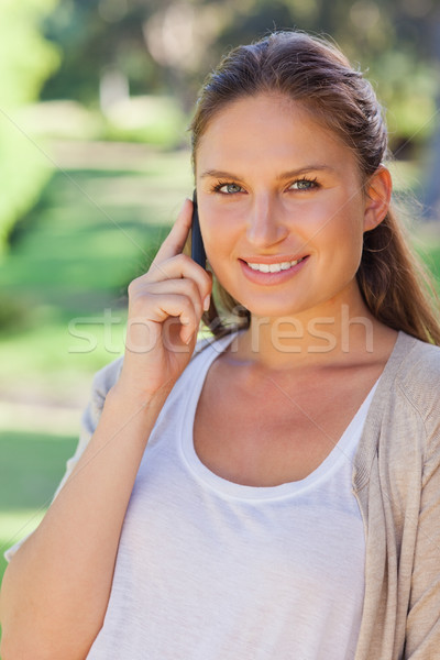 Close up of smiling woman on her cellphone in the park Stock photo © wavebreak_media