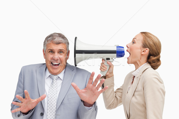 Businesswoman using a megaphone after her colleague against white background Stock photo © wavebreak_media
