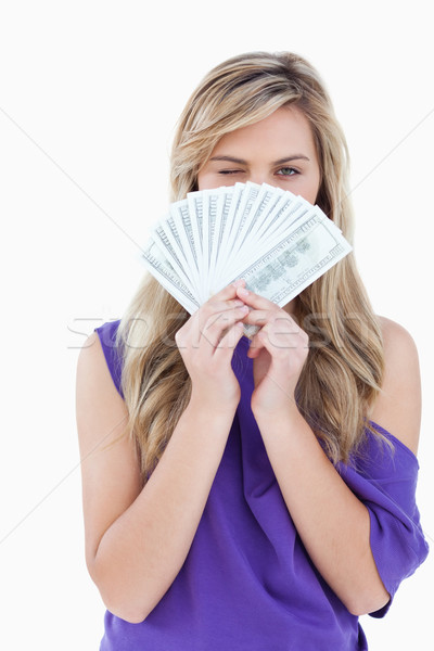 Young blonde woman blinking an eye while holding a fan of bank notes Stock photo © wavebreak_media